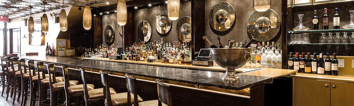 Bar interior with stools, glassware and warm lighting